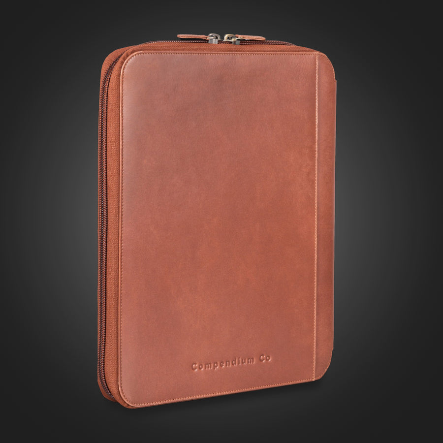 Compendium Co. dark brown leather compendium closed, standing on dark background